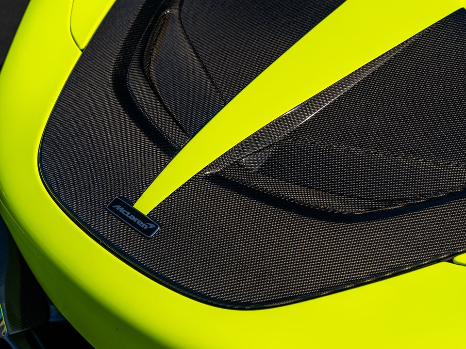 Woven carbon fibre hood ducts and badge on a lime green supercar